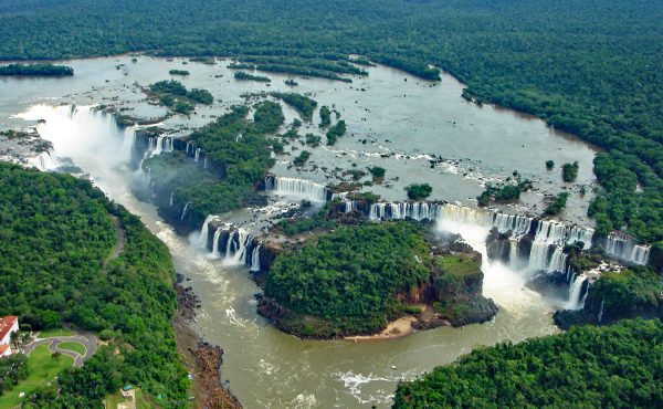 The wide cascades of Iguazu Falls surrounded by rainforest The wide cascades of Iguazu Falls surrounded by rainforest