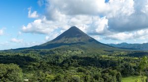 The cone of Arenal Volcano above rainforest and hot springs